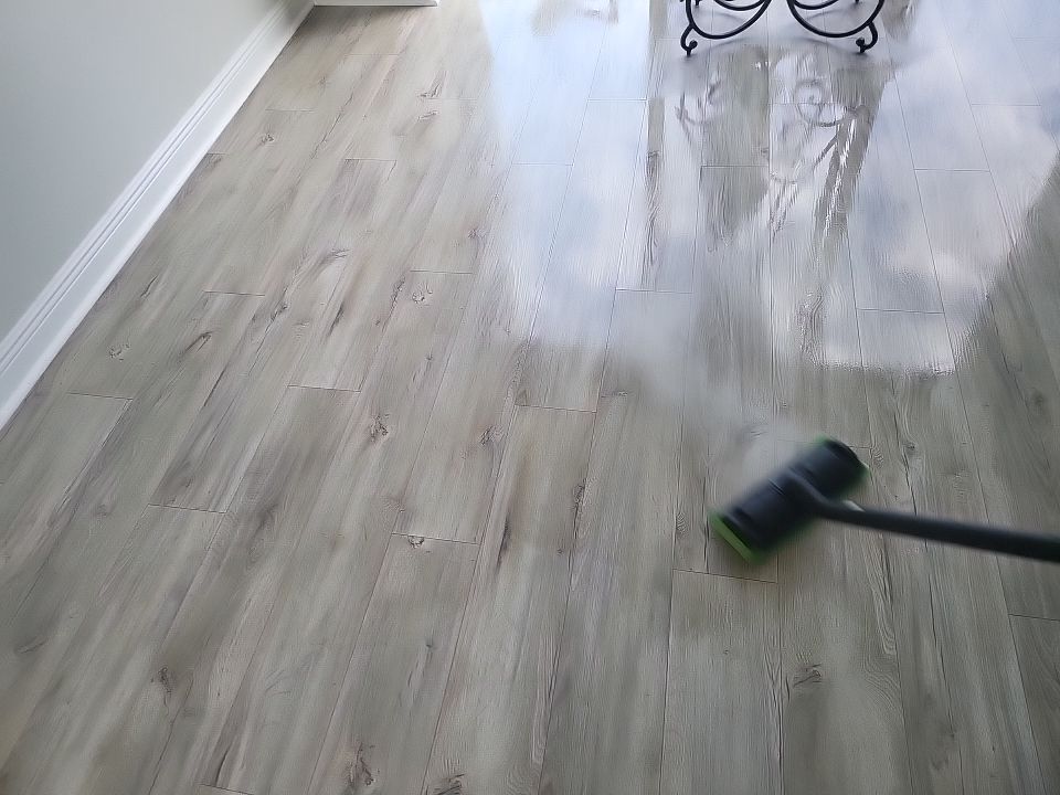 Close-up of steam cleaner sanitizing restored hardwood floors